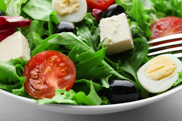 Bowl of fresh mixed salad leaves with tomatoes closeup