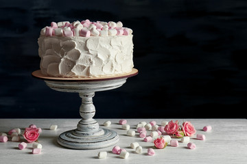 Delicious cake with marshmallows on wooden table