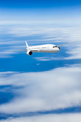 Podróż samolotem, samolot latający w błękitne niebo nad chmurami - obrazy, fototapety, plakaty