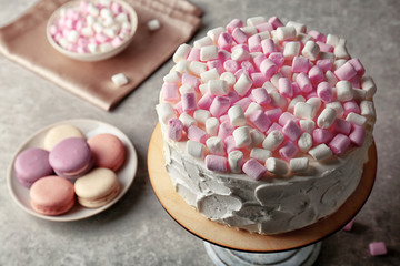 Delicious cake with marshmallows on table