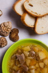 Mushroom soup in green plate, dried wild mushrooms and white bre