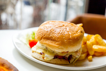 Delicious Big Burger with Beef, Tomato, Cheese and Lettuce in Cafe