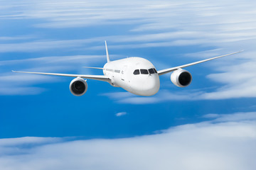 Fototapeta na wymiar Podróż samolotem, samolot latający w błękitne niebo nad chmurami