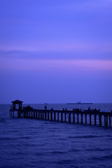  Filed wooden bridge into silhouette in the sea against sunrise sunset