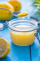 Lemon Curd in Jar on Blue Wooden Background, Close-up
