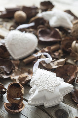 Lifestyle of dry leaves and white Christmas toys on a wooden old table.