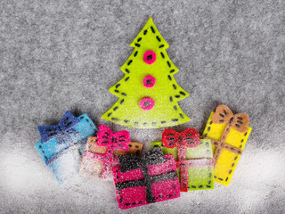 Christmas background with felt decoration:  Christmas tree and  colorful gifts