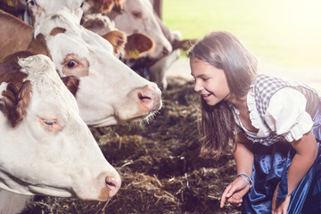 Lächelndes Mädchen bei Kühen im Stall