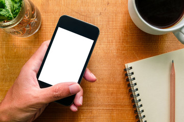 Hand holding a smartphone on wood background