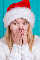 Christmas time. Young woman wearing santa claus hat red dress on blue background