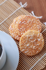 Crispy Rice Crackers with Hot cup of coffee on wooden table back