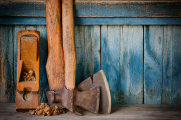 Older axes, plane and chips on a blue wooden background, with space for text