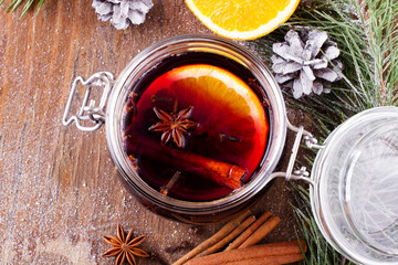 Christmas drink with orange fruit, anise, cinnamon and cloves on wooden table