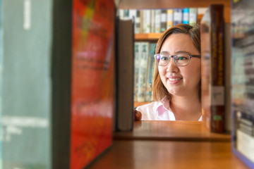 Young Woman find a book in library.