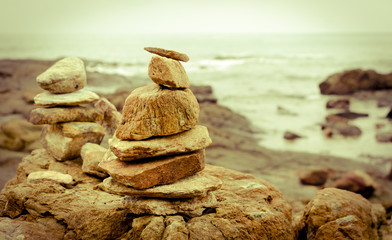 stack of stones rocks arranged at seaside coast with sepia tone effect
