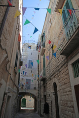 narrow street w colorful flags