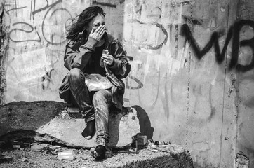 homeless beggar stilzhizni, health, social kontsept- tired, miserable homeless hungry woman smokes a cigarette