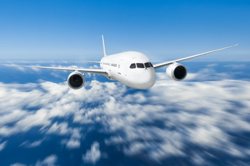 Naklejka premium Podróż samolotem, samolot latający w błękitne niebo nad chmurami