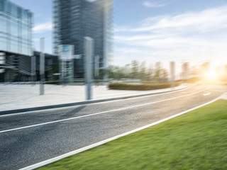 empty asphalt road by modern office building.