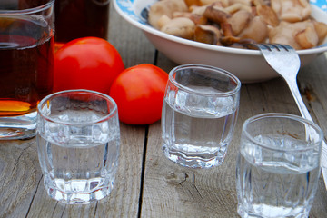 three glasses of vodka on a wooden table