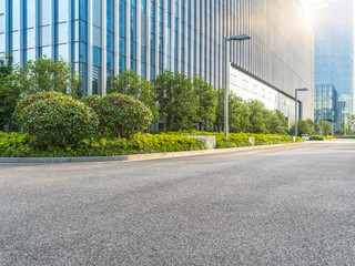 empty asphalt road by modern office building.