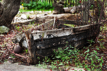Last place of old broken boat in autumn garden.