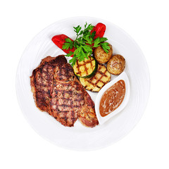 Grilled steaks, baked potatoes and vegetables on white plate isolated on white background.