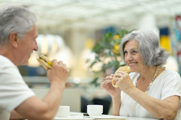 Beautiful elderly couple eating fast food
