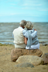 Senior couple at sea at sunset