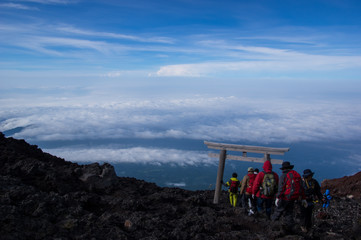 富士山頂下界を眺めながら下山する登山者