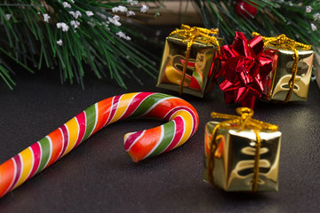 Christmas gift, tree branch and decorations on dark slate background