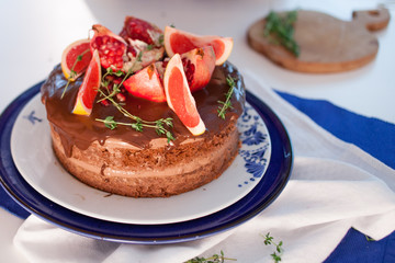 Two girls making a cake on the kitchen. Beautiful cake with cream and decoration of grapefruit and pomegranate