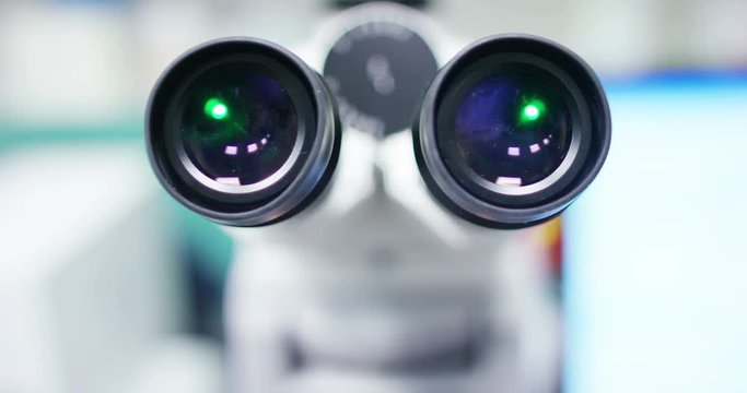 One of point of view of microscope in professional laboratory with green lights switch on