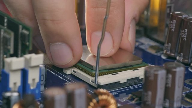 Engineer plug in CPU microprocessor to motherboard socket
