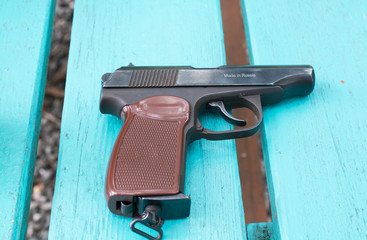 The Makarov Pistol with brown grip. It located at green table.
