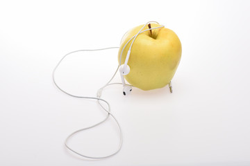 Obraz premium Yellow apple and headphones