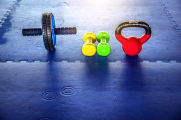 Colorful Dumbbell in gym on blue floor rubber