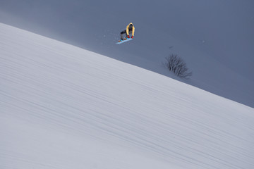 Snowboarder jumping on mountains. Extreme snowboard freeride sport.