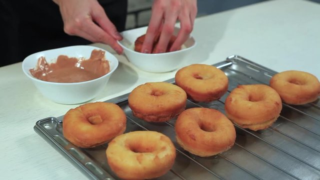 housewife covers glaze donuts in the kitchen