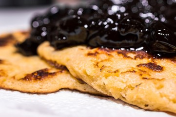 Homemade american sweet pancakes with cherry, fruit jam on a white napkin