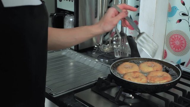 Frying donuts in a kitchen, detail of a kitchen, sweet dessert