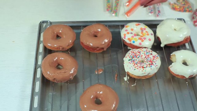 woman sprinkles colored powder ready donuts