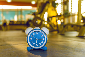 Time Clock on rubber floor blue color with blue fitness gym. Time and healthy take care you self Concept