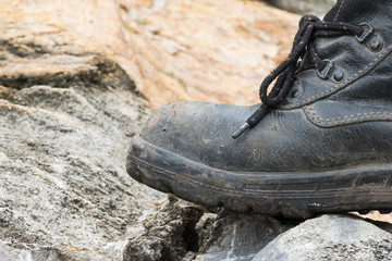 Trekking leather boot on the rock