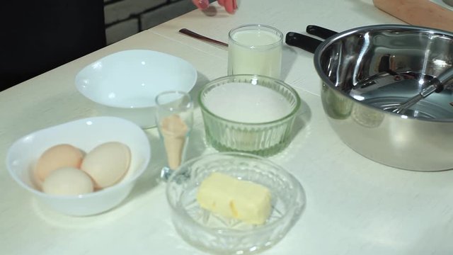 Baking donuts in rural kitchen - dough recipe ingredients (eggs, flour, milk, butter, sugar)