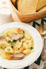 Meat soup with dumplings on white background.