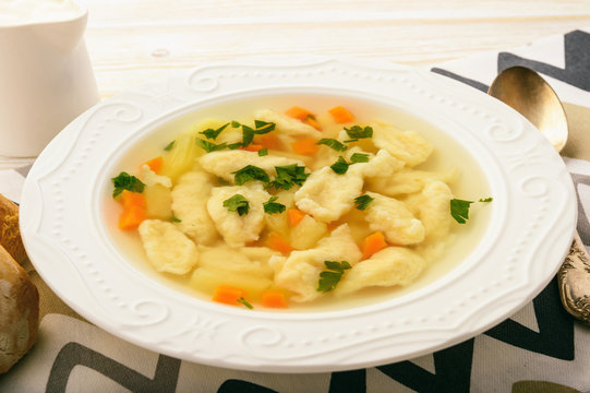 Soup with dumplings on white background.