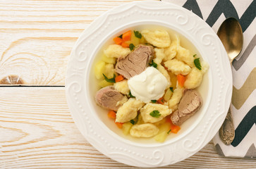 Meat soup with dumplings on white background.