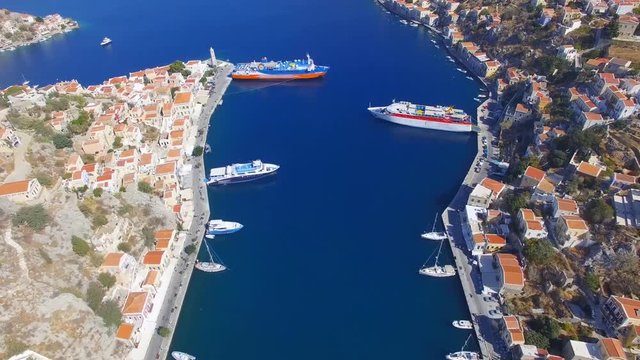 Symi island - Aerial footage of Colorful houses and small boats at the heart of the village