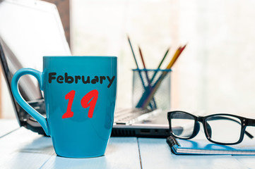 February 19th. Day 19 of month, calendar on auditor workplace background. Winter time. Empty space...